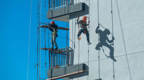 couple-workers-fixing-climbing-scaffolding-while-following-all-safety-measures