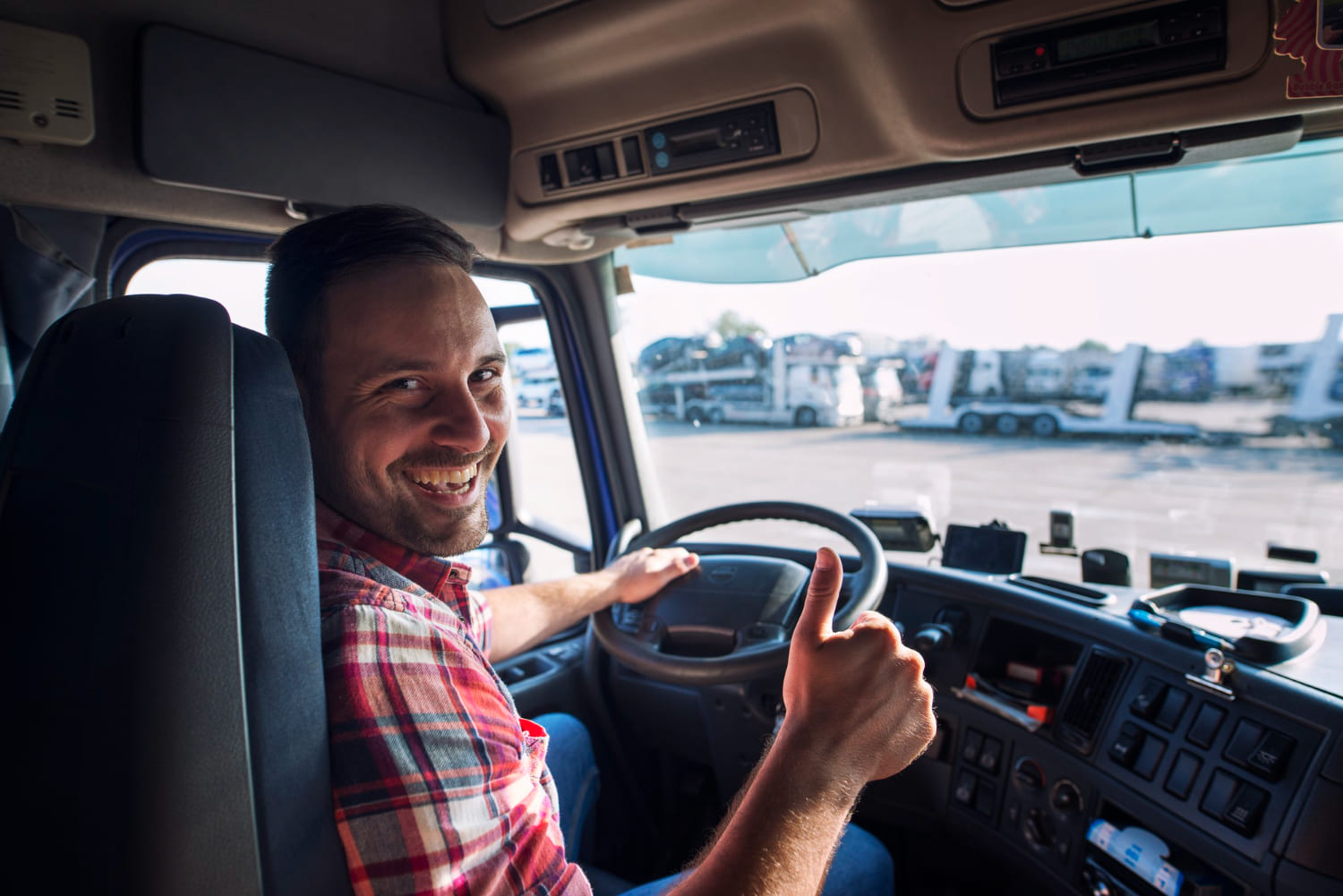 portrait-truck-driver-sitting-his-truck-holding-thumbs-up